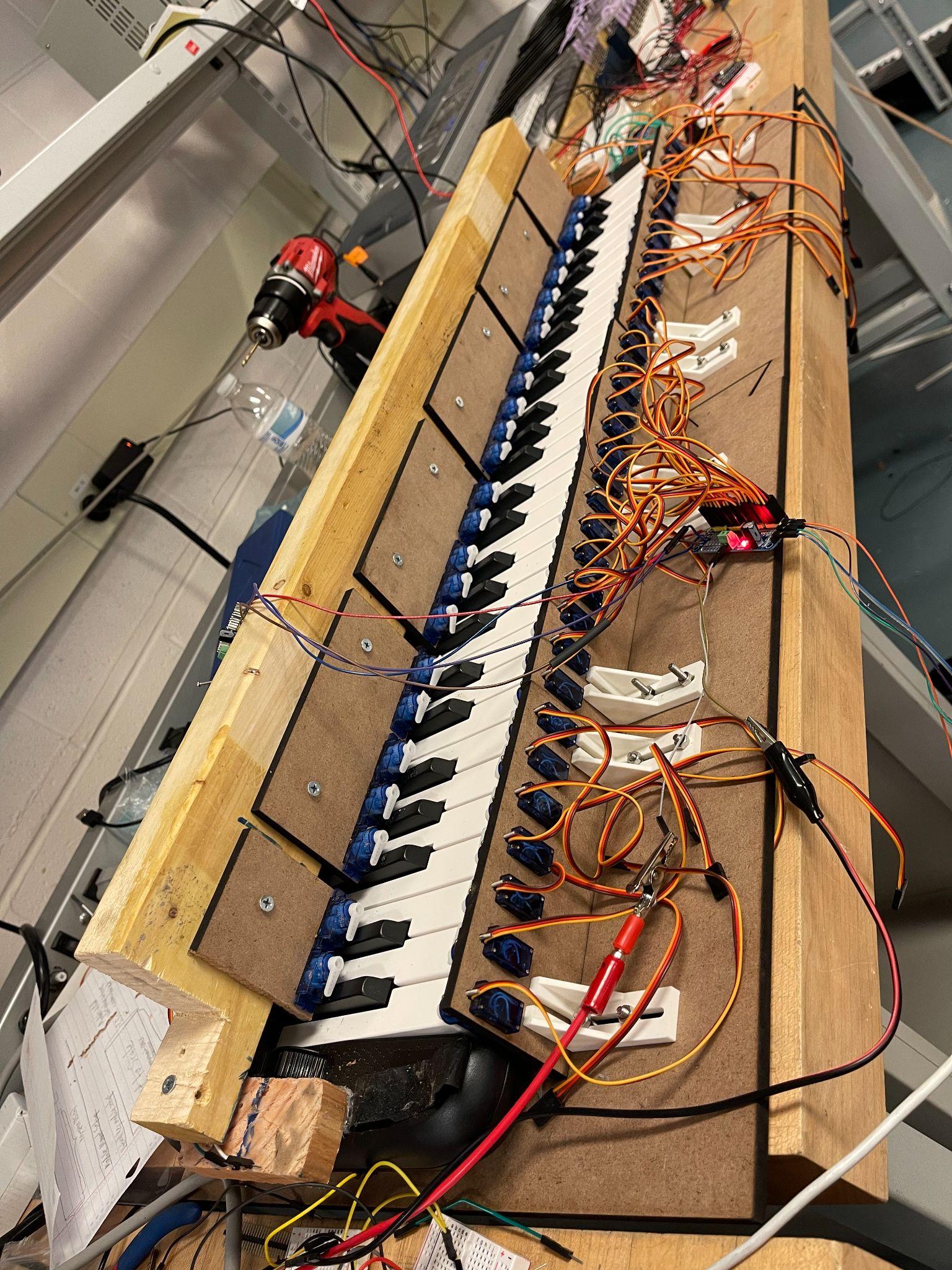 Servo-actuated piano player prototype on a workbench