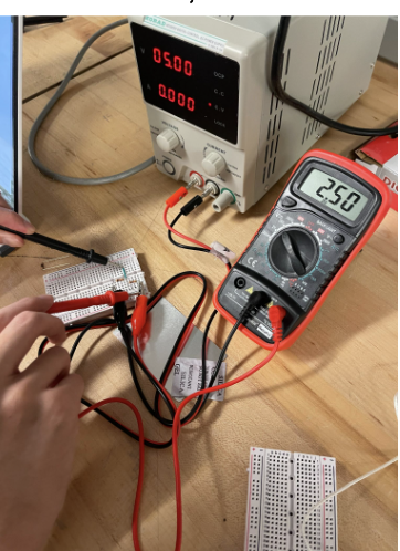 Breadboard voltage divider test with a bench supply and multimeter